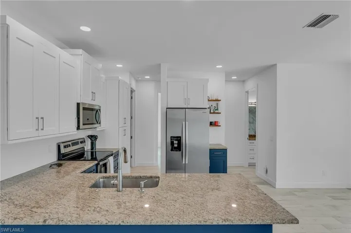 Kitchen featuring white cabinetry, sink, appliances with stainless steel finishes, light hardwood / wood-style flooring, and kitchen peninsula