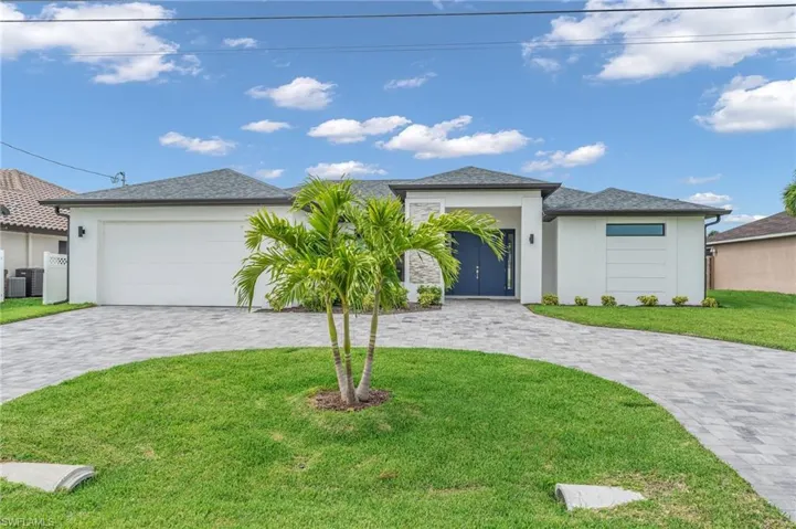View of front of home featuring a garage, central AC unit, and a front lawn