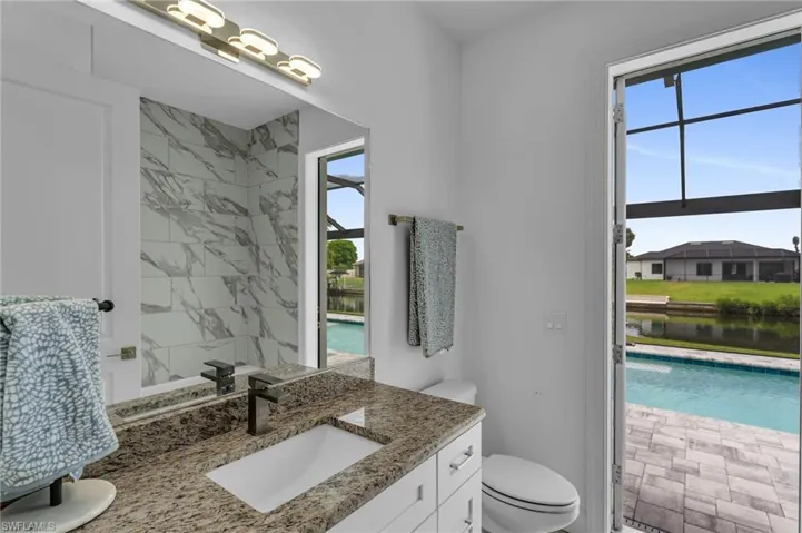 Bathroom with toilet, a wealth of natural light, and vanity