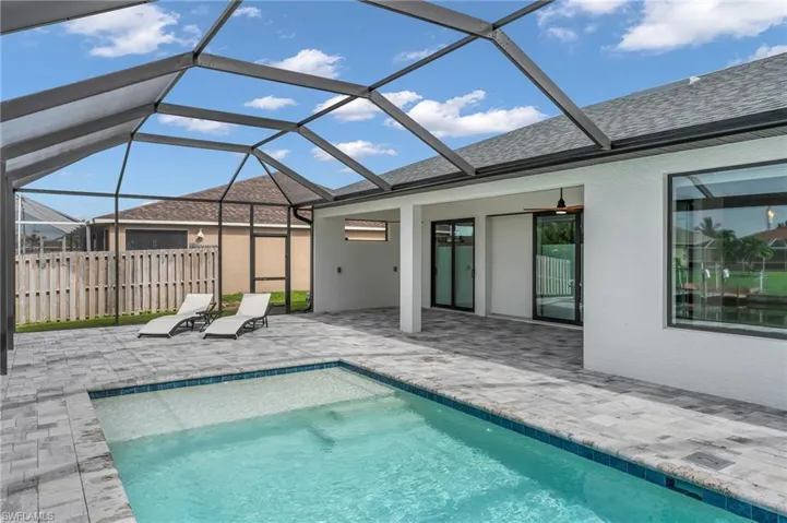 View of pool with a patio and glass enclosure
