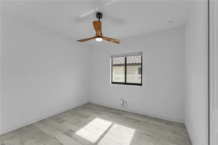 Empty room featuring light wood-type flooring and ceiling fan