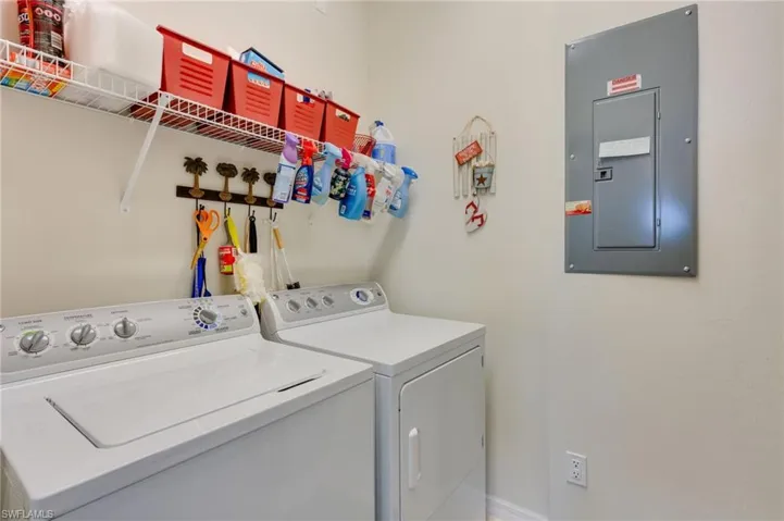 Laundry room featuring electric panel and washer and clothes dryer