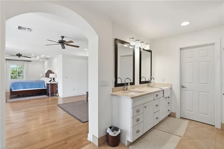 Full bath with double vanity, recessed lighting, ensuite bath, and ceiling fan