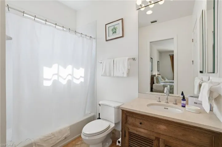 Ensuite bathroom with vanity, shower / tub combo, and a chandelier
