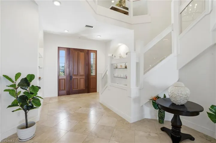 Foyer entrance featuring stairs and baseboards