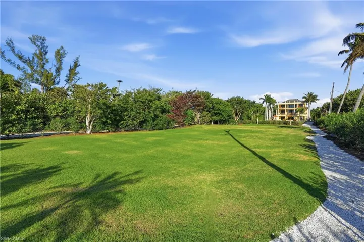 View of grassy yard featuring view of scattered trees
