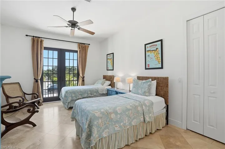 Tiled bedroom featuring french doors, access to exterior, and ceiling fan