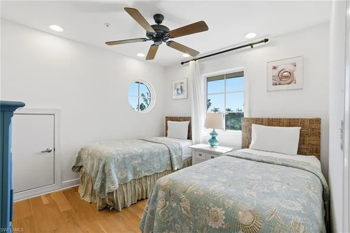 Bedroom with light wood finished floors, ceiling fan, and recessed lighting