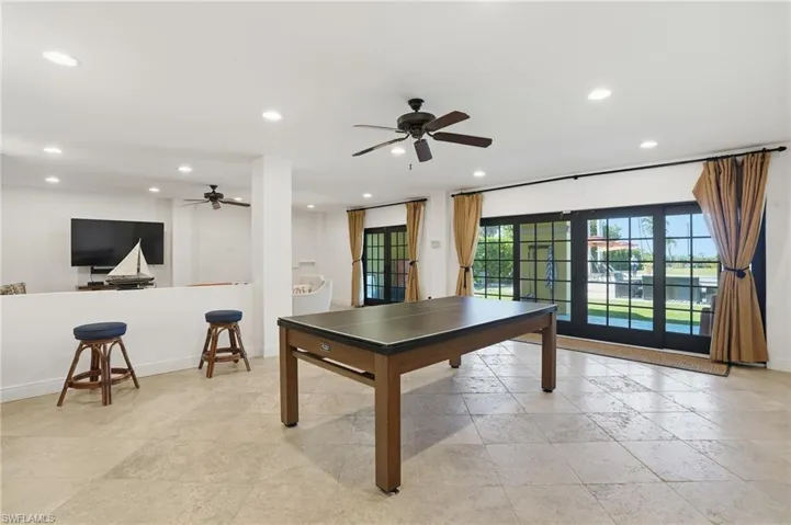 Game room with stone tile flooring, ceiling fan, and recessed lighting