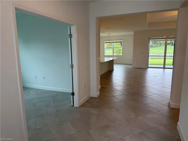 Hallway featuring baseboards and light tile patterned floors