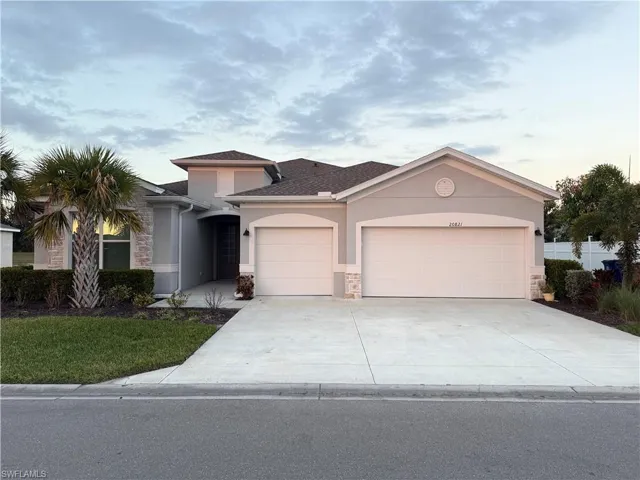View of front of property featuring stucco siding, stone siding, a garage, and concrete driveway