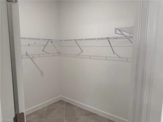 Walk in closet with light tile patterned floors