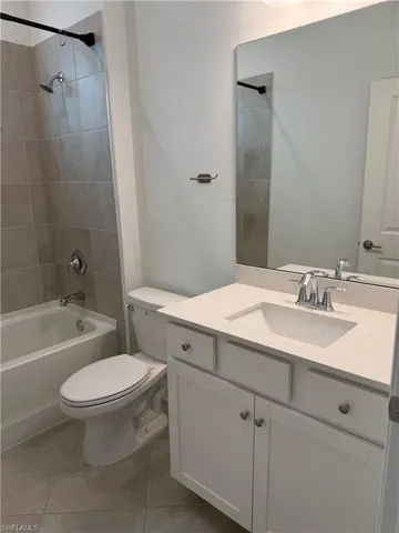 Full bath 3 with vanity,  shower combination, and light tile patterned floors