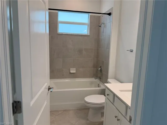 Bathroom 3 with vanity, light tile patterned floors, and washtub / shower combination