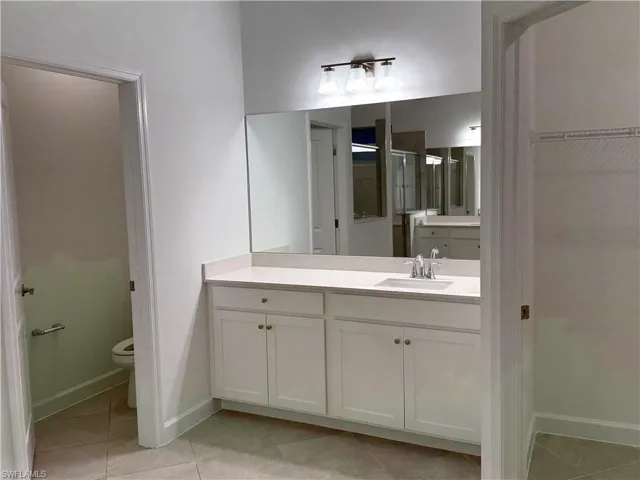 Primary Bathroom featuring vanity and light tile patterned flooring