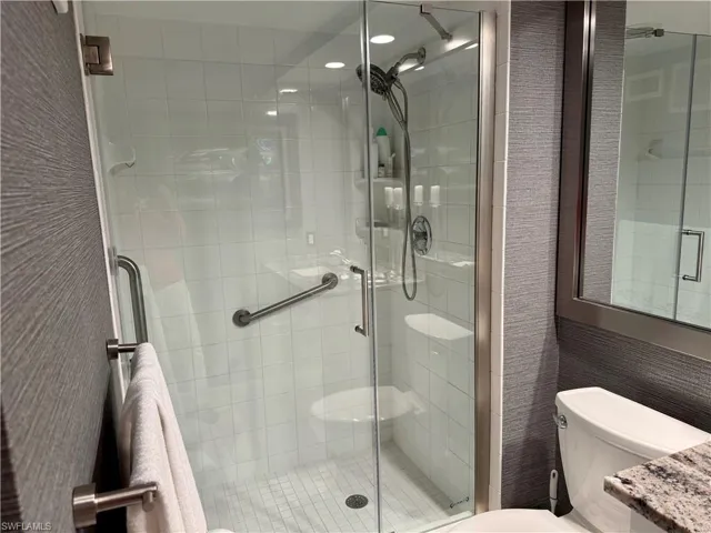 Bathroom with an enclosed shower, vanity, and toilet