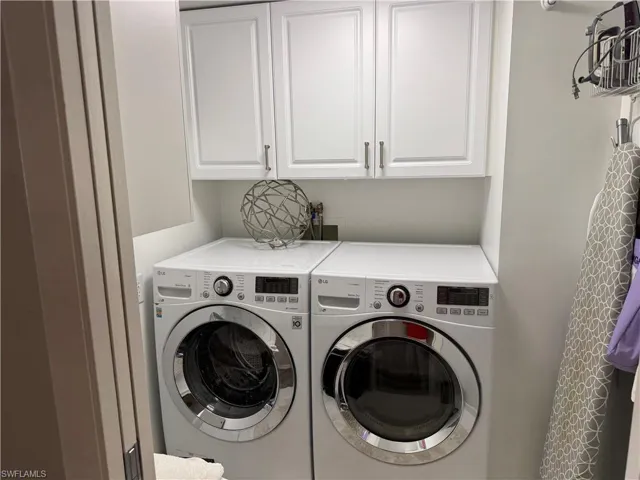 Laundry area with cabinets and separate washer and dryer