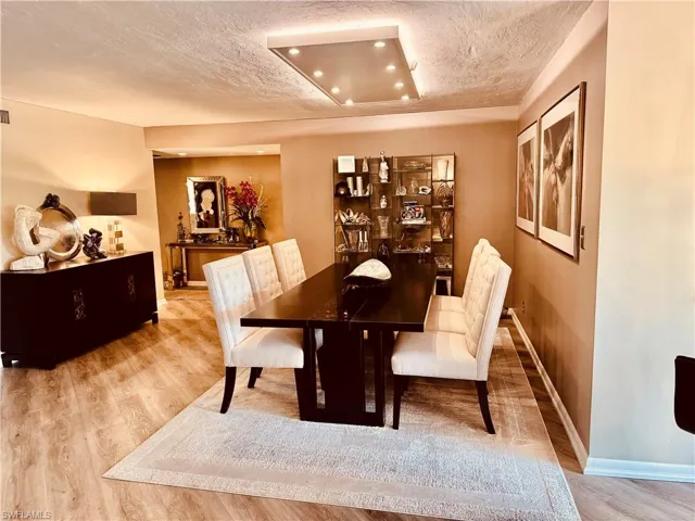 Dining space featuring light hardwood / wood-style floors and a raised ceiling
