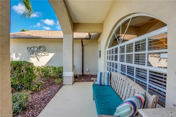 Entrance to property with stucco siding and roof with shingles