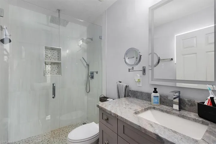 3825 Rose Ave - Main/Master bathroom featuring full update, shower and modern lighting