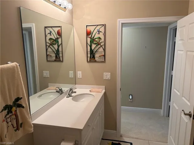 Half bath with vanity and light tile patterned floors