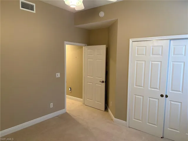 Unfurnished bedroom featuring light colored carpet and a closet