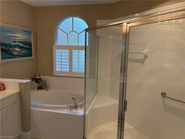 Full bath with vanity, a shower stall, and a garden tub