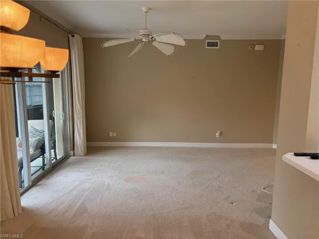 Empty room featuring crown molding, light carpet, and ceiling fan