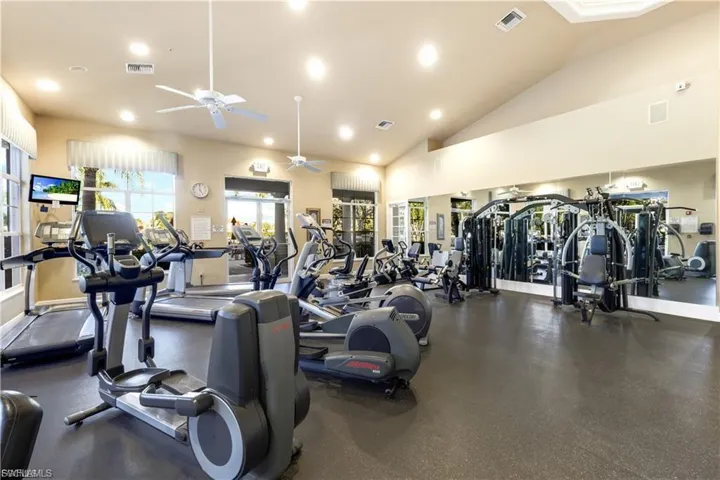 Exercise room featuring ceiling fan, recessed lighting, and lofted ceiling