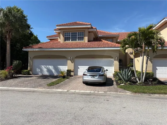 Mediterranean / spanish home with stucco siding, driveway, a tiled roof, and a garage
