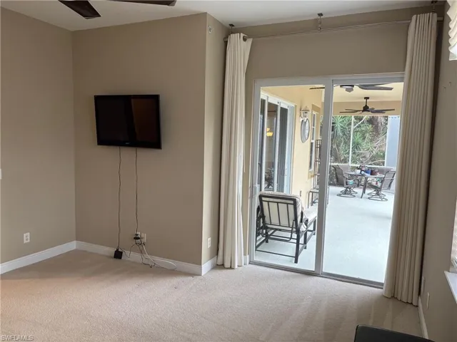 Unfurnished living room featuring ceiling fan and light colored carpet