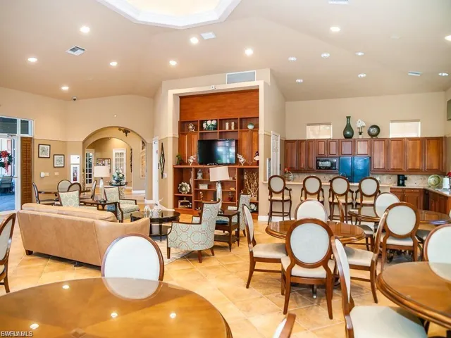 Dining space featuring recessed lighting, arched walkways, lofted ceiling, and light tile patterned flooring