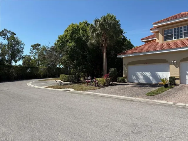 View of property exterior featuring stucco siding, driveway, a garage, and a tile roof