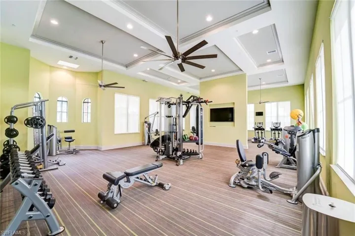Workout area with coffered ceiling, ceiling fan, and recessed lighting