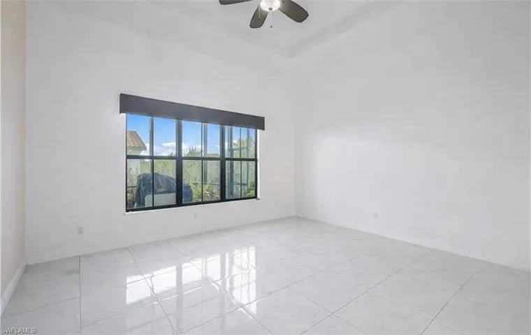 Spare room with a high ceiling and a ceiling fan