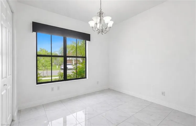 Spare room featuring a chandelier and light marble finish floors
