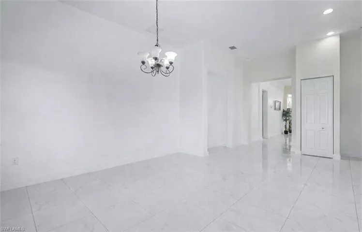 Empty room featuring hanging lights and baseboards