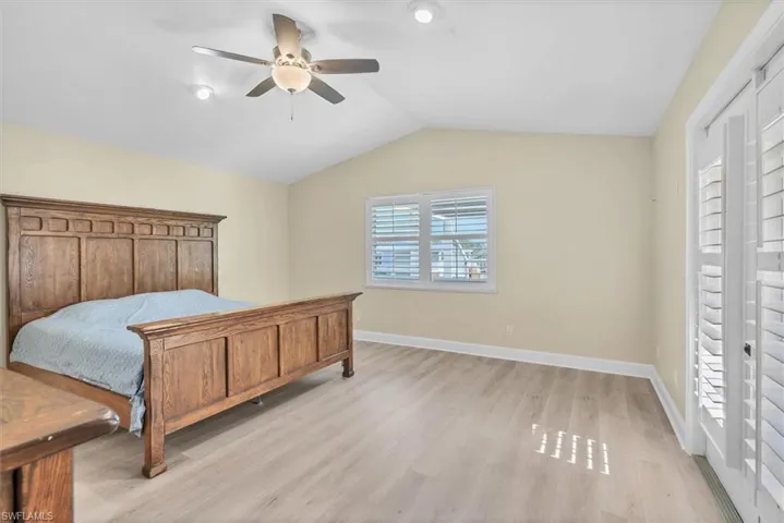 Bedroom featuring ceiling fan, light hardwood / wood-style flooring, and vaulted ceiling
