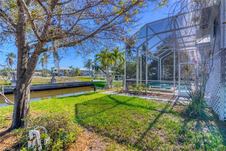 View of yard with glass enclosure and a water view