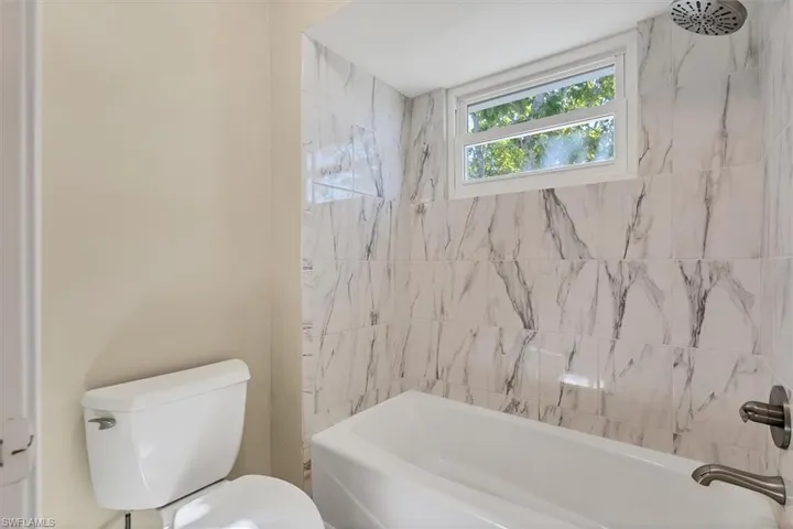 Bathroom featuring toilet and tiled shower / bath