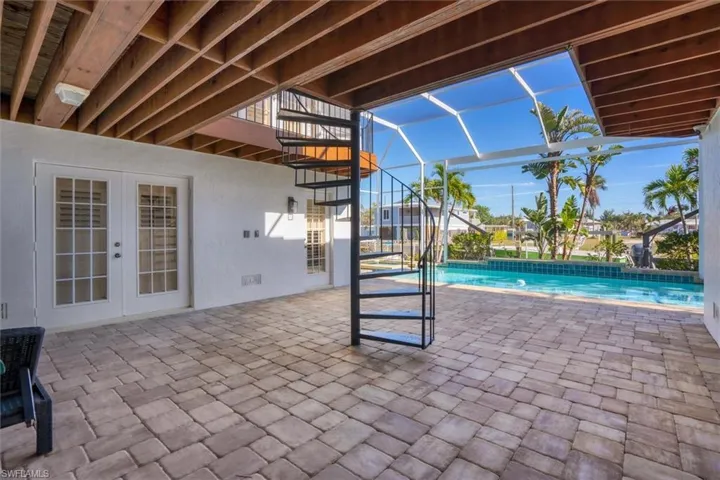 View of swimming pool with glass enclosure, french doors, and a patio