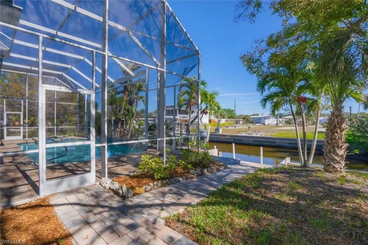 View of swimming pool featuring a water view and glass enclosure