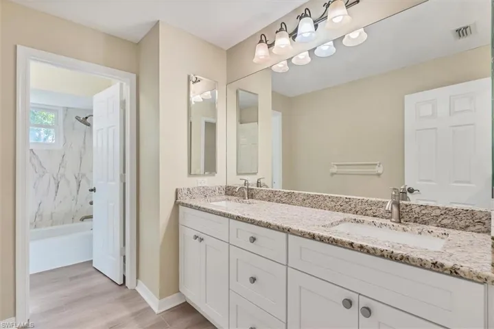 Bathroom featuring vanity, hardwood / wood-style flooring, and tiled shower / bath