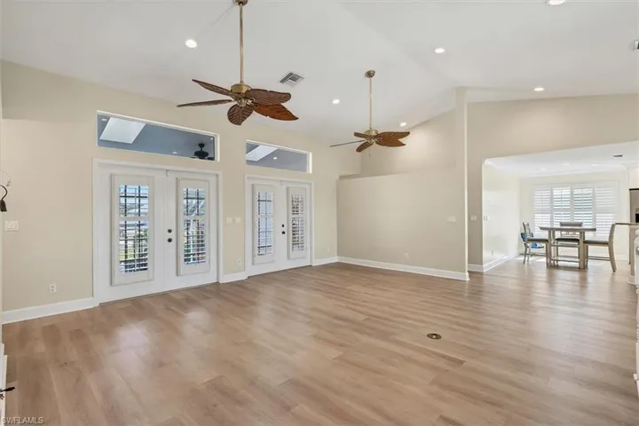 Unfurnished living room featuring ceiling fan, plenty of natural light, french doors, and light wood-type flooring