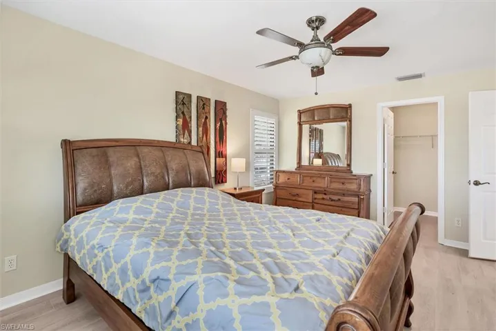 Bedroom featuring ceiling fan, a closet, a spacious closet, and light hardwood / wood-style flooring