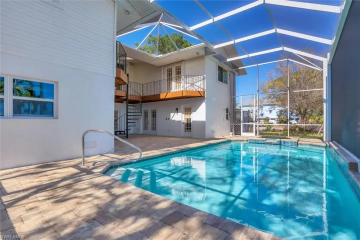 View of pool featuring a jacuzzi, french doors, a patio, and glass enclosure
