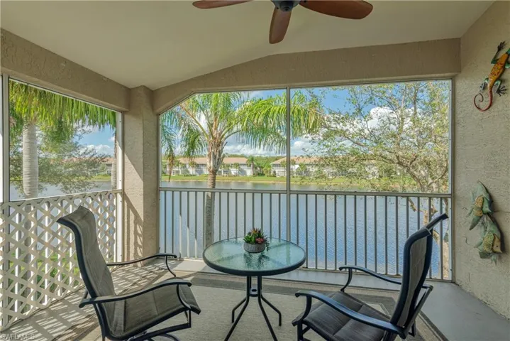 Sunroom featuring ceiling fan, a water view, and lofted ceiling