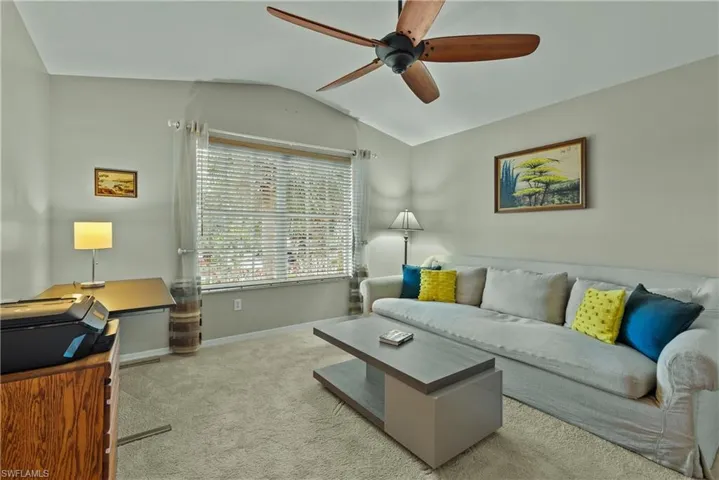 Bedroom/Den featuring light colored carpet, vaulted ceiling, and ceiling fan
