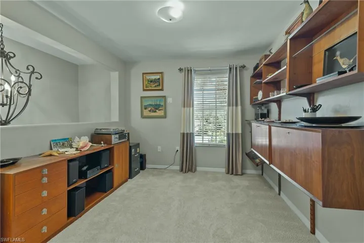 Carpeted office with a notable chandelier