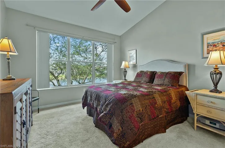 Bedroom featuring ceiling fan, lofted ceiling, and light carpet